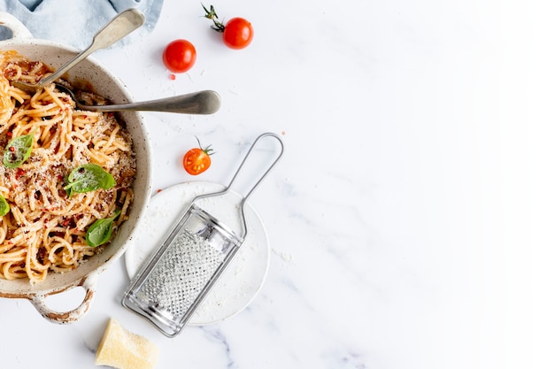 Espaguetis con salsa de tomate marinara cubiertos con parmesano y albahaca fotografía de alimentos