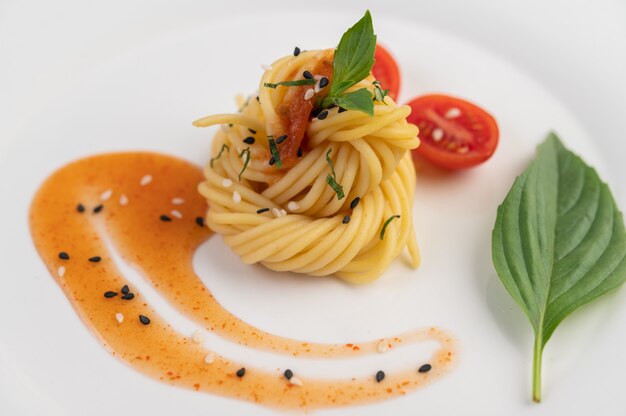 Espaguetis salteados bellamente dispuestos en un plato blanco.