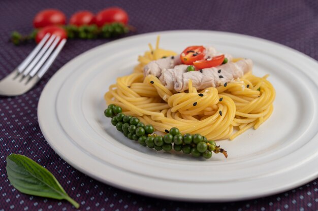 Espaguetis salteados bellamente dispuestos en un plato blanco.