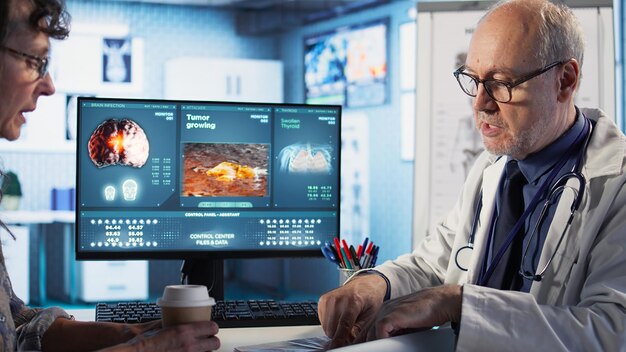 Especialista y anciana comentan radiografías para la medicina preventiva contra el cáncer