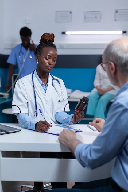 Especialista en medicina general del hospital de atención médica que revisa los ingredientes, los efectos secundarios y los beneficios de los medicamentos recetados. Paciente enfermo esperando que el médico de la clínica analice los compuestos antibióticos.