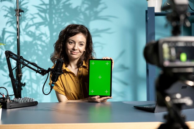 Especialista en tecnología que presenta una maqueta de grabación de tableta con una cámara profesional