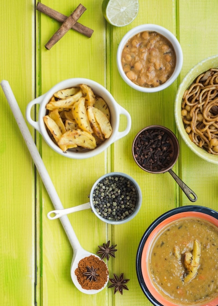 Especias aromáticas y platos en la mesa verde