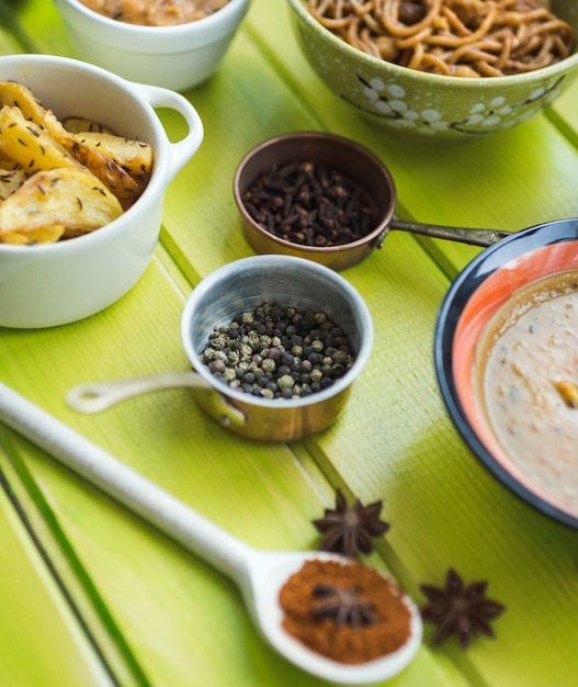 Foto gratuita especias frescas cerca de platos en la mesa verde