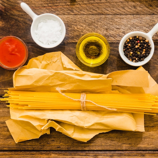 Foto gratuita especias y salsa de tomate cerca de espagueti