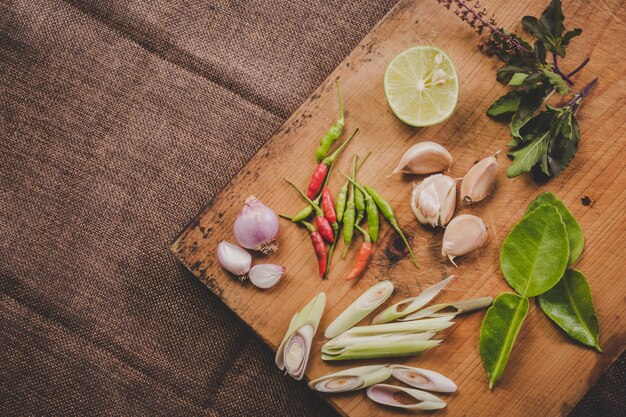 Especias Tom Yum que se colocan en una tabla de cortar de madera marrón y tienen una madera de color marrón oscuro.