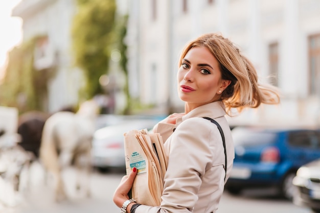 Espectacular mujer rubia con el pelo ondeando colgando solo llevando el periódico a casa