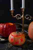 Foto gratuita espeluznante linterna de calabaza tallada de halloween con candelabros