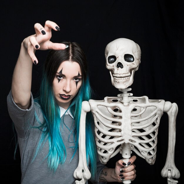Espeluznante mujer joven con espeluznante esqueleto