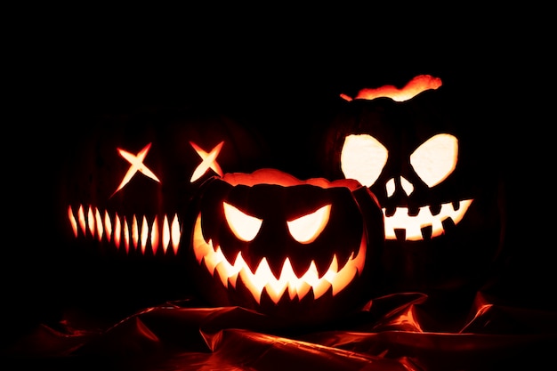 Foto gratuita espeluznantes caras brillantes de calabaza de halloween