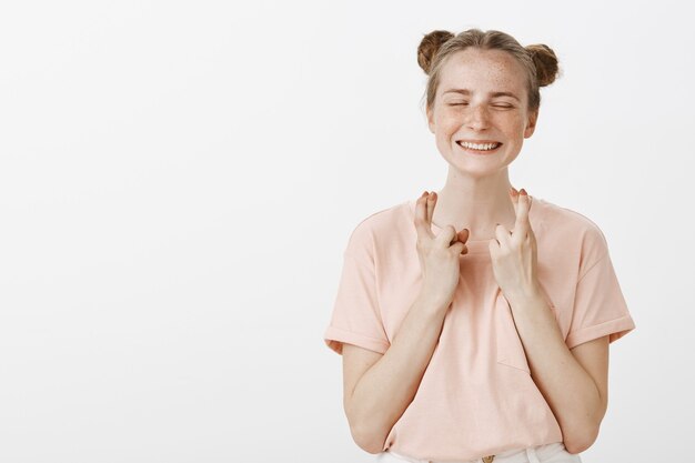 Esperanza sonriente adolescente posando contra la pared blanca