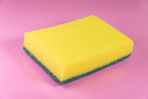 Esponja de cocina sobre la superficie rosa