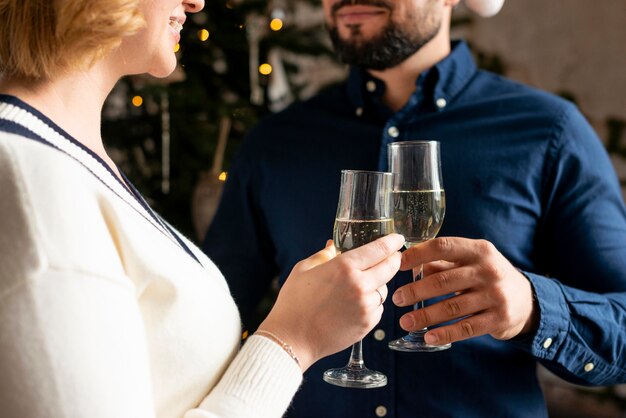 Esposa y esposo animando con champán el día de Navidad