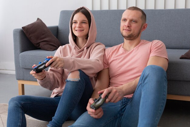 Esposa y esposo jugando videojuegos juntos en casa