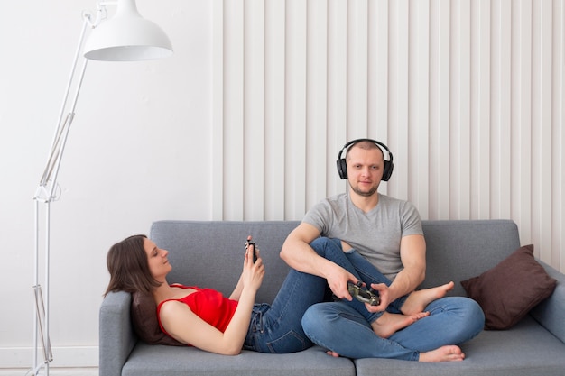 Foto gratuita esposa y esposo jugando videojuegos juntos en casa