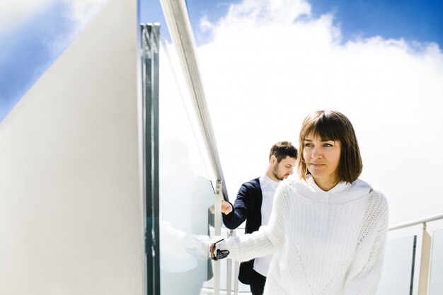 Esposa y esposo subiendo escaleras en el cielo