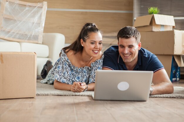 Esposa mostrando a su marido el televisor nuevo que van a comprar para su nueva casa