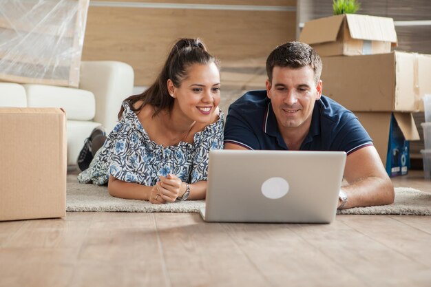 Esposa mostrando a su marido el televisor nuevo que van a comprar para su nueva casa