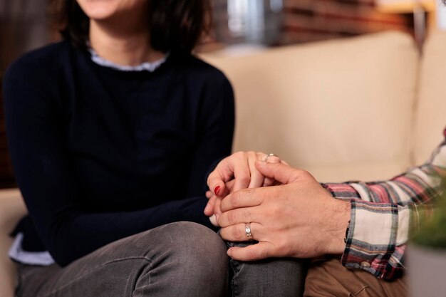 Esposo y esposa tomándose de la mano después de resolver un conflicto matrimonial con la ayuda del consejero en la sesión de terapia. Una pareja feliz sintiéndose bien con la reconciliación de la relación en el cargo.