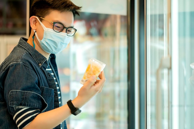 Esposo masculino con máscara facial protección mano elegir vagetable compras en supermercado supermercado nuevo estilo de vida normal concepto de salud e ideas