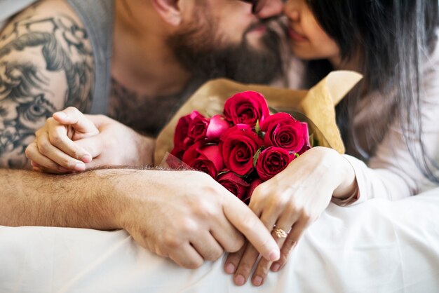 Esposo sorprendido esposa con ramo de rosas rojas