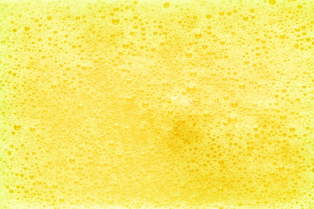 Espuma amarilla sobre líquido coloreado