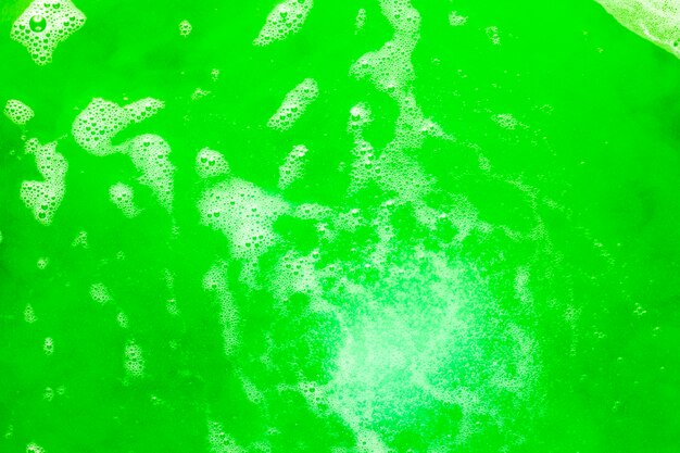 Espuma y burbujas en líquido de color verde.