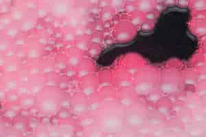 Foto gratuita espuma rosa en agua negra