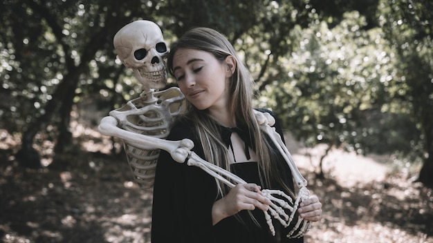 Foto gratuita esqueleto abrazando detrás de la dama parpadeante