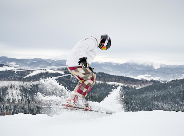 Esquiador masculino esquiando en hermosas montañas de invierno