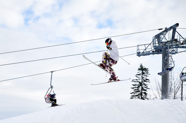 Esquiador masculino saltando en el aire en la estación de esquí