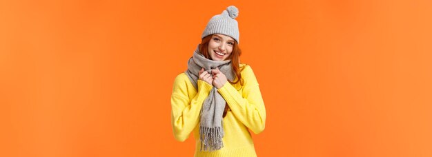 Se está poniendo frío afuera linda y encantadora mujer bonita pelirroja usa gorro de invierno gris y bufanda poniéndose