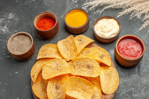 Establecer para papas fritas que contienen diferentes especias mayonesa y salsa de tomate en mesa gris