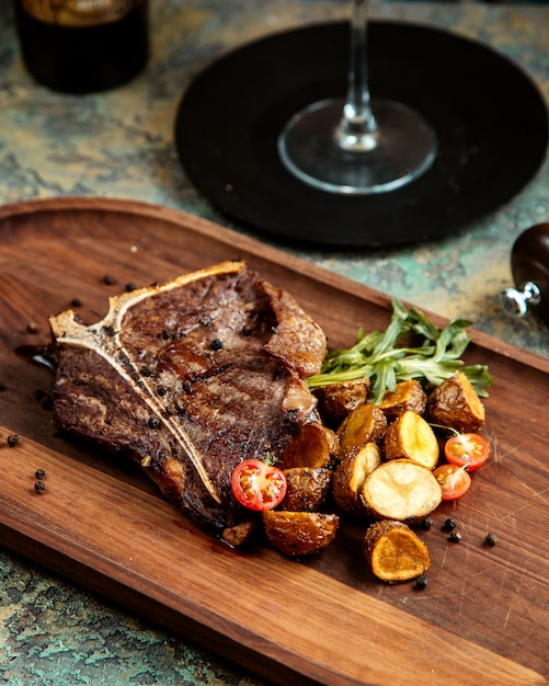 Foto gratuita estaca a la parrilla con pimienta negra al horno tomates patata y romero a bordo