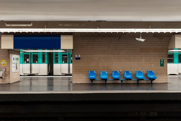 Estación de metro con metro y asientos