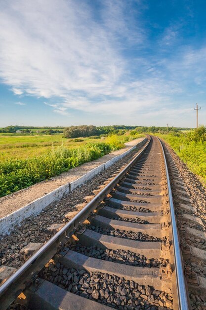 Estación de tren contra el hermoso cielo al atardecer Paisaje industrial con ferrocarril colorido cielo azul nublado