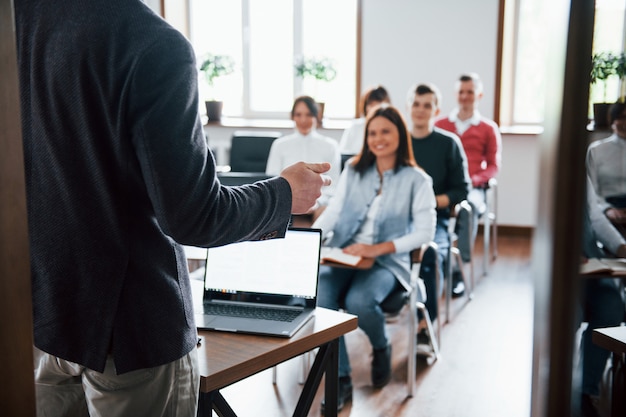 El estado de ánimo alegre. Grupo de personas en conferencia de negocios en el aula moderna durante el día