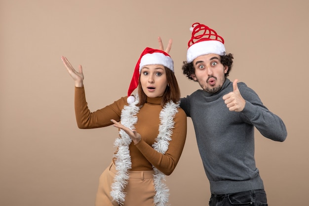 estado de ánimo de navidad con emocionado fresco satisfecho encantadora pareja con sombreros rojos de santa claus concentrados