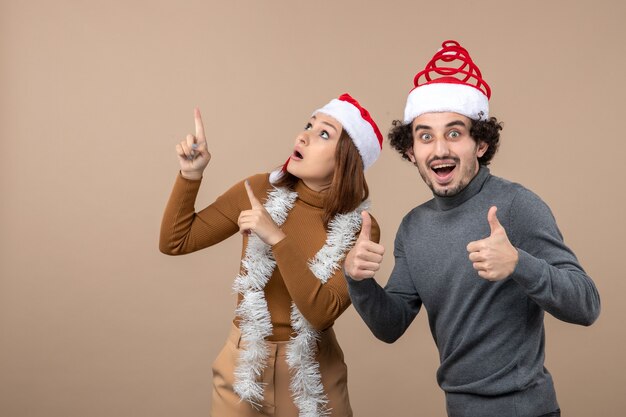 estado de ánimo de navidad con emocionado fresco satisfecho encantadora pareja con sombreros rojos de santa claus divirtiéndose juntos