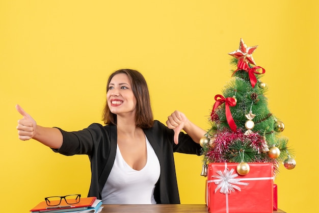 Estado de ánimo de Navidad con hermosa joven sentada a la mesa en la oficina