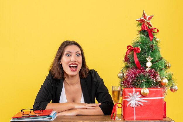 Estado de ánimo de Navidad con la joven dama de negocios feliz sentado en la oficina