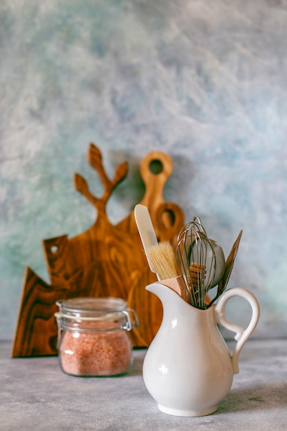 Estante de cocina con varias hierbas, especias, semillas, legumbres, tablas de cortar, utensilios en blanco