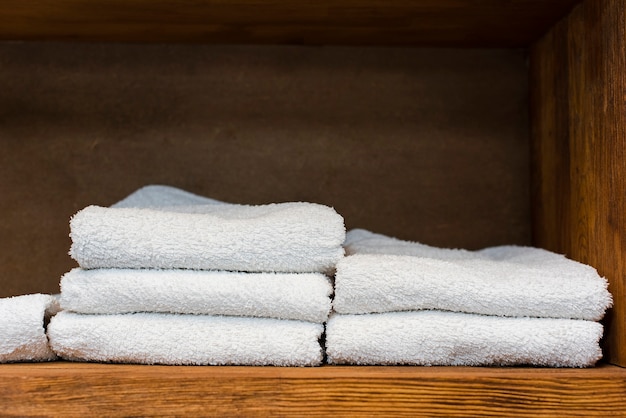 Estante de madera con toallas blancas limpias