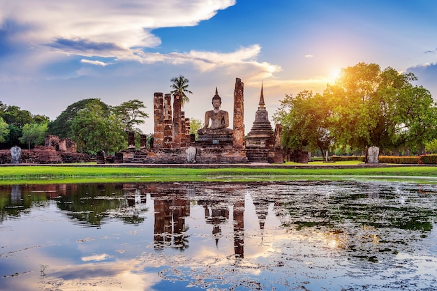 Estatua de Buda y el templo Wat Mahathat en el recinto del Parque Histórico de Sukhothai