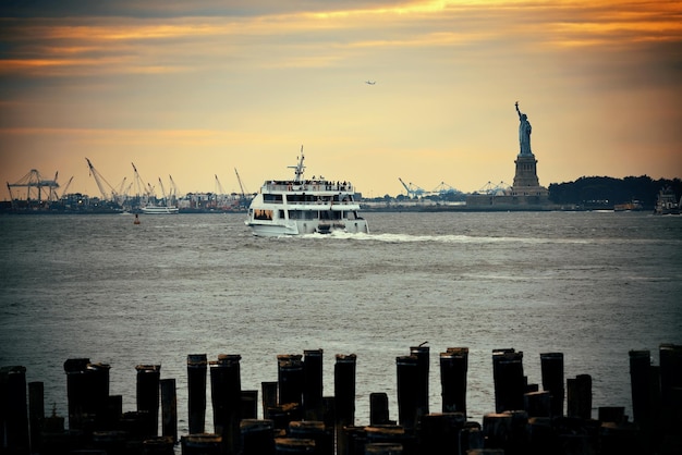Estatua de la libertad en el puerto de la ciudad de Nueva York con muelle.