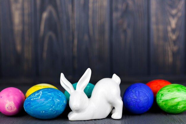 Estatuilla de conejo cerca de huevos de colores