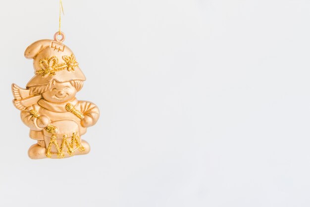 Estatuilla dorada para navidad contra fondo blanco