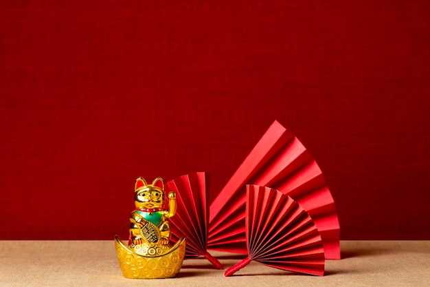 Estética japonesa con abanicos rojos y gato de la suerte.