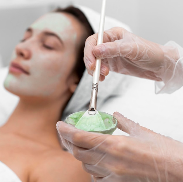 Esteticista aplicando mascarilla en clienta