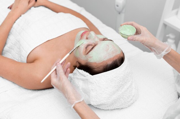 Esteticista aplicando mascarilla en clienta